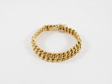 un bracelet en or avec un motif de tresse sur fond blanc