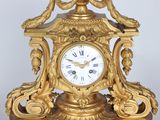a gold clock that is sitting on top of a table