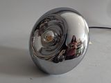 a chrome ball with a reflection of a person in it