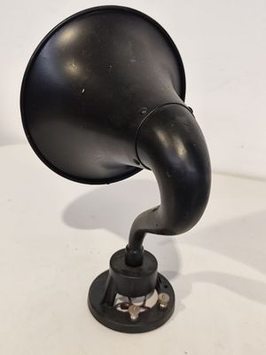 un vieux gramophone noir posé sur une surface blanche