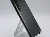 a close up of a cell phone on a stand on a white surface