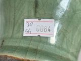 a close up of a green vase with a tag on it