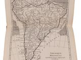 an old book with a map of south america on top of it