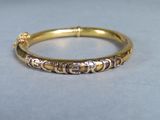a close up of a gold bangle with small beads on it