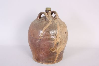 a brown vase that is sitting on a white surface