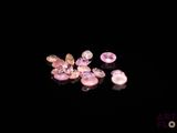 some pink and white diamonds are on a black surface