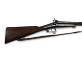 un vieux fusil avec un canon en bois et une poignée en bois