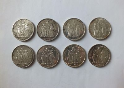 a group of six different coins sitting on top of a white surface