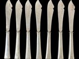 six silverware spoons and a knife on a black background