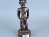 une petite statue en bois représentant un homme tenant un bébé dans ses bras