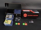 une boîte contenant des cartes, des dés et d'autres objets, posée sur une table