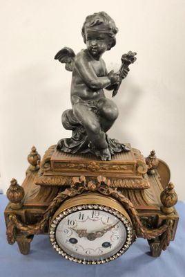 a clock with a statue of a boy on top of it