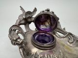 a silver vase with a purple glass inside of it