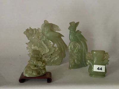 Plusieurs figurines en jade sont exposées sur une table, accompagnées d'une étiquette indiquant leur prix.