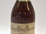 une vieille bouteille de rhum repose sur une surface blanche