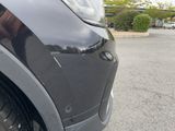 a close up of a car ' s front bumper and tire