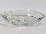 un saladier en verre transparent posé sur une surface blanche, avec un fond blanc