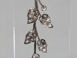 sterling silver leaf earrings with diamonds on a clear acrylic stand