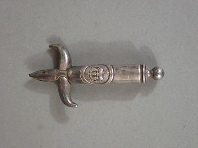 a silver object on a table with a knife in it