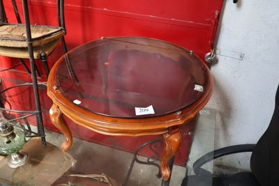 une table avec un plateau en verre et une chaise placée devant un mur rouge