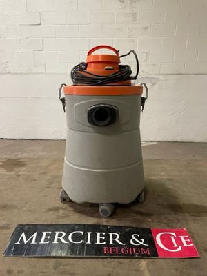 un aspirateur orange et gris posé sur le sol, à côté d'un panneau