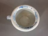 a blue and white cup with a handle on a table