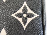 a close up of a black purse with a white flower on it