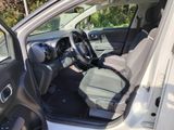 the interior of a car with the door open and the driver ' s seat down