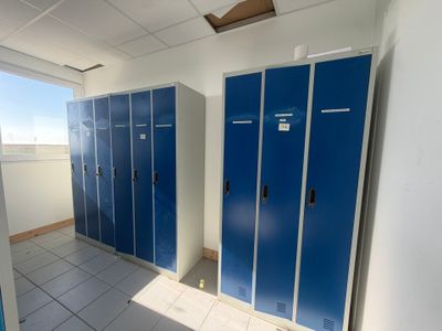 several blue lockers are lined up in a row in a room