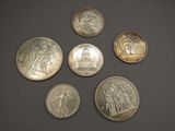 six different types of coins on a table with a black background