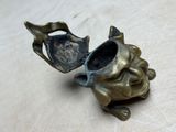 brass figurine of a frog holding a teapot on a table