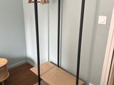 un porte-manteau dans un coin de la pièce, près d'une porte