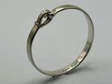 a close up of a silver ring with a knot on it