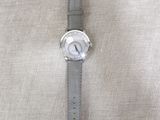the watch is sitting on the table next to the cloth