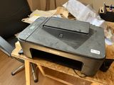 a printer sitting on top of a desk next to a chair