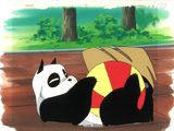 un panda allongé avec une balle