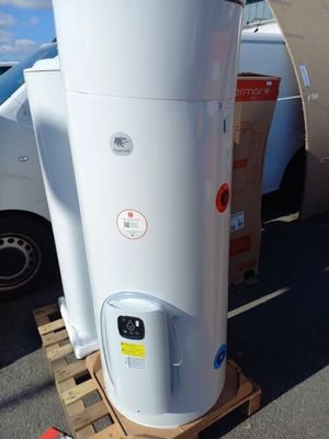un chauffe-eau blanc posé sur une palette dans un parking