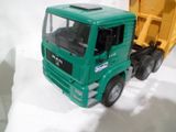 un camion-jouet vert avec un camion-benne jaune derrière lui