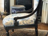 une chaise bleue et blanche placée devant une cheminée