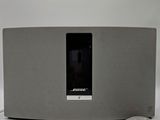 bose music system with remote and remote control on white surface