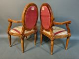 two wooden chairs with red upholstered seats on a grey background