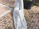 a statue of a woman sitting on a stone slab