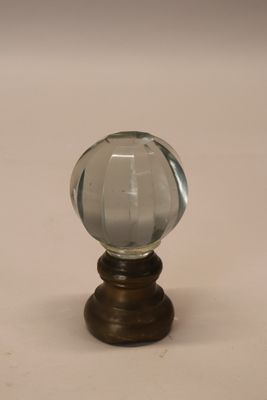 une petite boule de verre posée sur un socle en bois