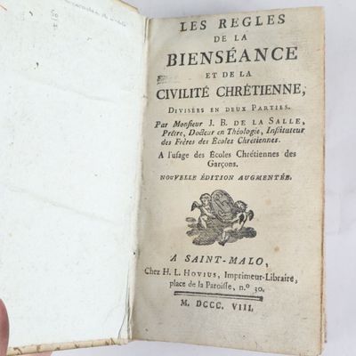 Quelqu'un tient un livre à la main sur lequel figure l'image d'un dragon.