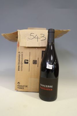 a bottle of wine sitting next to a cardboard box