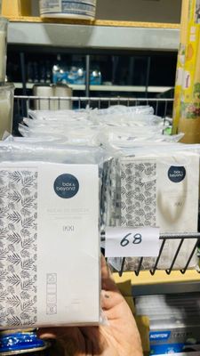 a person holding a box of toilet paper in a store