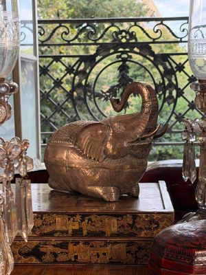 an elephant statue sitting on top of a table next to a lamp