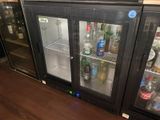 bottles of alcohol are lined up in a glass case in a bar
