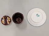 a white plate and a cup of coffee on a table