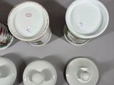 several different types of cups and saucers sitting on top of a table
